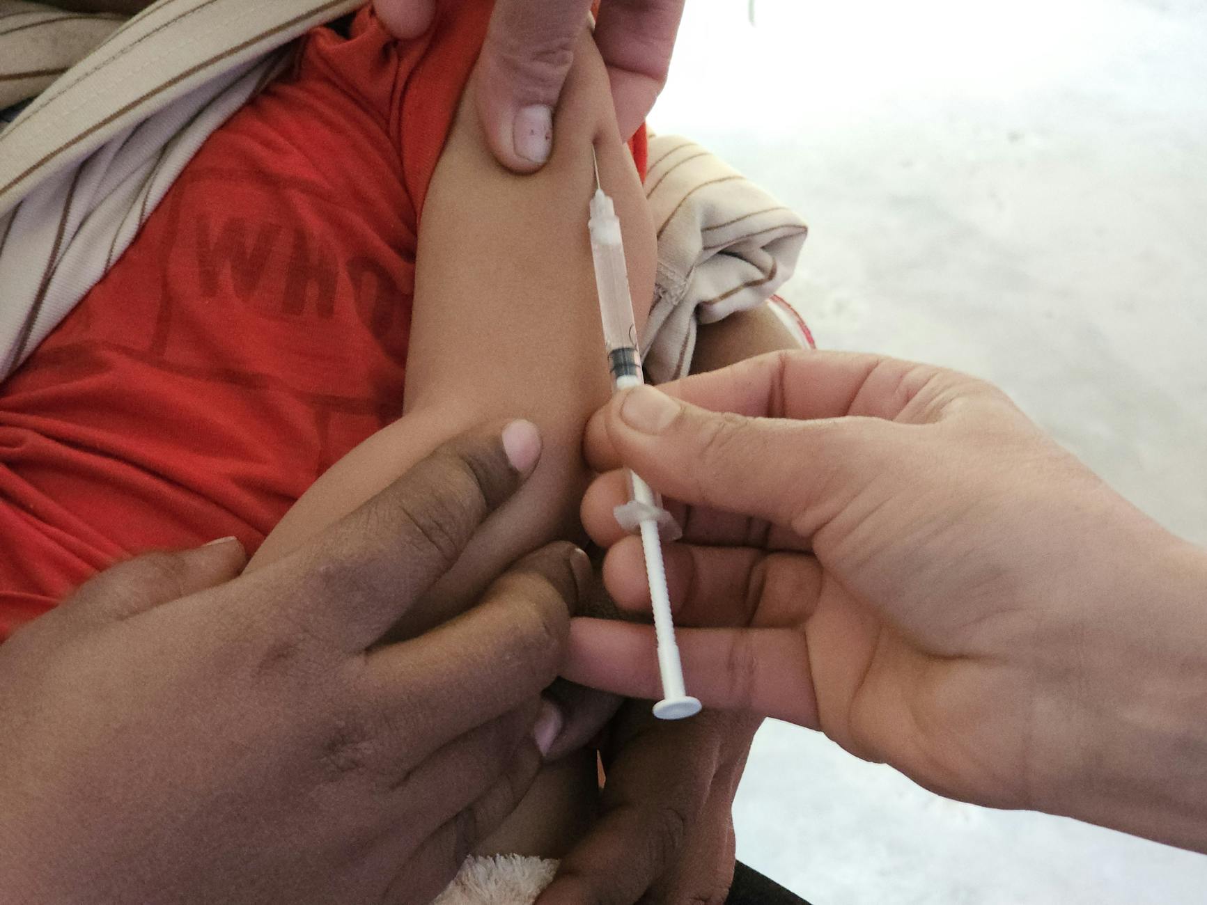 Child receiving measles vaccination at a public health clinic