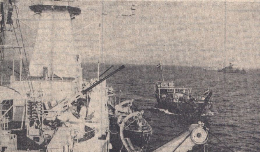 US Navy warships in the Persian Gulf with smoke rising on the horizon