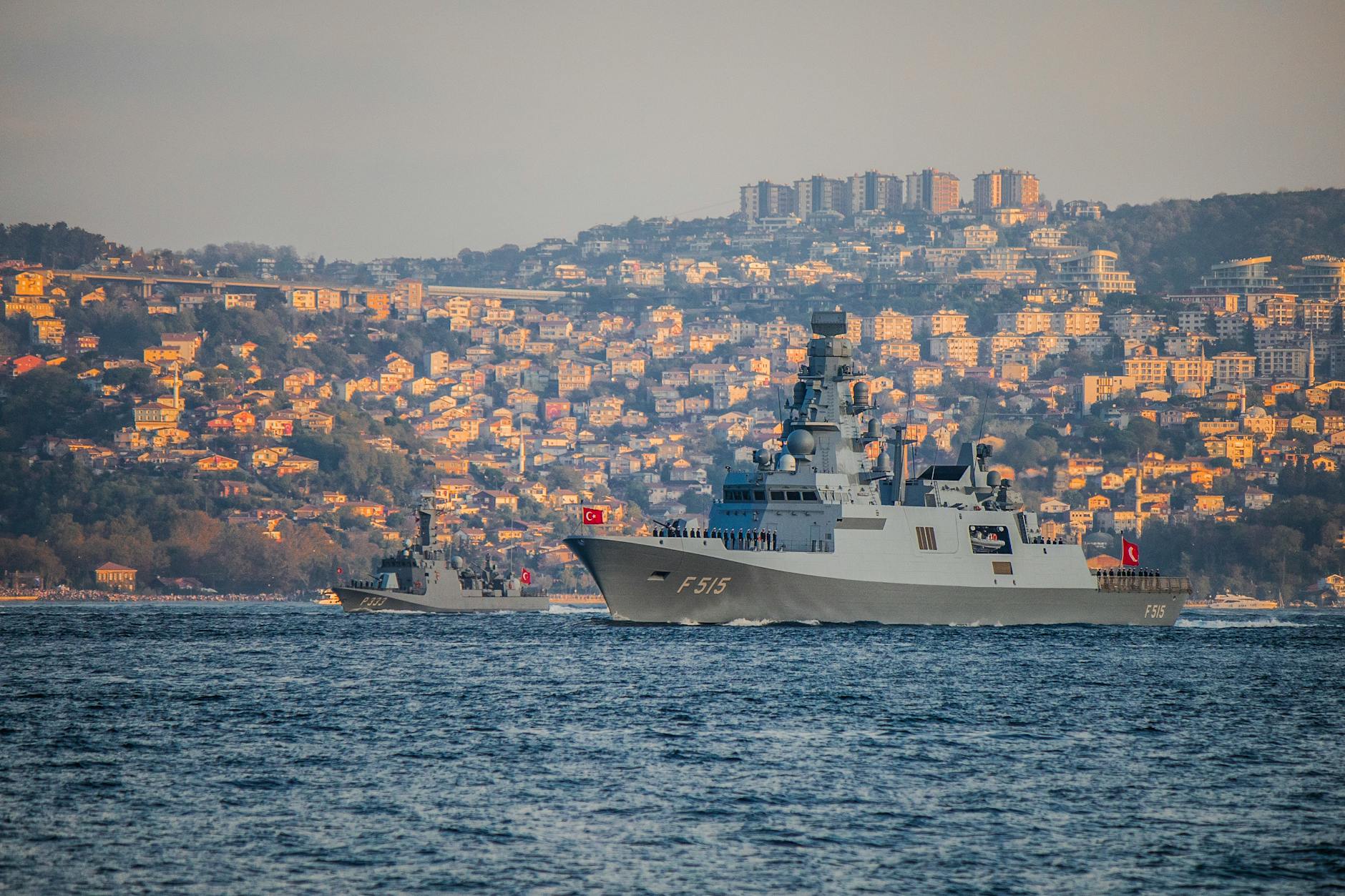 US Navy warship patrolling the Strait of Hormuz with an oil tanker in the background